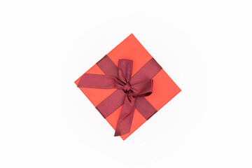 A red gift box wrapped in a red ribbon.