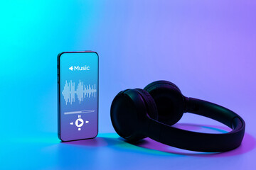 Music banner. Mobile smartphone screen with music application, sound headphones. Audio voice with radio beats on neon gradient background. Broadcast media music banner with copy space.