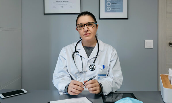 Portrait of female doctor looking at camera in her office