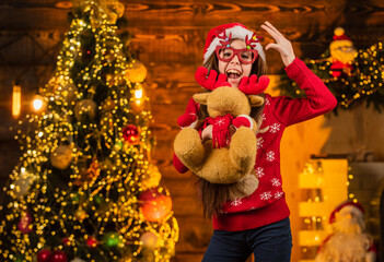 Best holiday. happy little girl hold reindeer toy present. new year party celebration. its christmas time. the best gift ever. childhood happiness. cheerful kid in santa costume. child love xmas