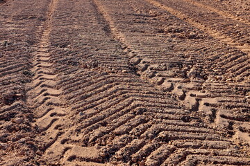 Traces de roues de tracteur dans un champ de terre.