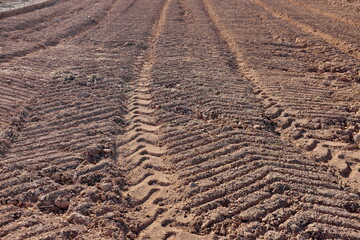 Traces de roues de tracteur dans un champ de terre.