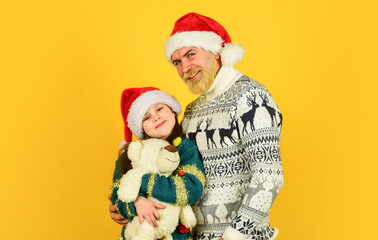 funny knitted sweater. father and daughter celebrate christmas. xmas party together. . winter family holiday. new year is here. bearded dad and small girl santa hat with toy