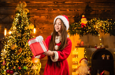 Obraz na płótnie Canvas Santa brought gifts. Time for miracles. All I want for christmas. Happiness and joy. Child happy excited girl find gifts near christmas tree. Merry christmas. Happy childhood concept. Kid santa hat