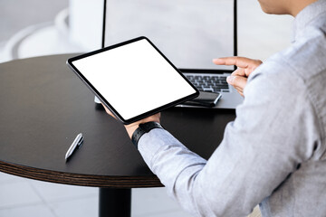 A man holding a tablet with a blank white screen. The blank space on the white screen can be used...