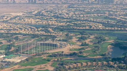 Aerial view to Golf course with green lawn and lakes, villas and houses behind it timelapse.