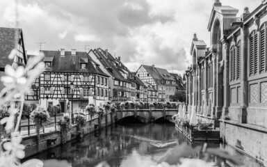 Beautiful view of Colmar city with flowers in water canal and traditional half timbered houses in...