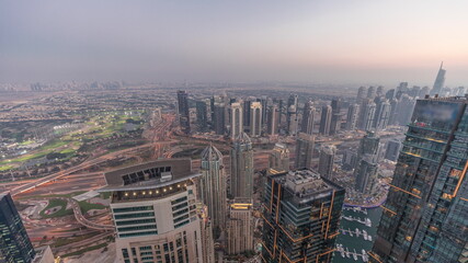 Panorama of Dubai Marina with JLT skyscrapers and golf course day to night timelapse, Dubai, United Arab Emirates.