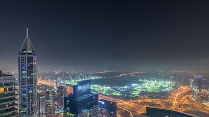 Aerial skyline with Golf Club, hotels and residential areas far away in desert in Dubai all night timelapse, UAE, top view