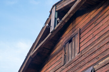 Fototapeta premium Old wooden building with blocked window and old-fashioned power supply