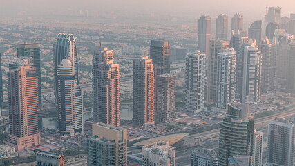 Fototapeta na wymiar JLT skyscrapers near Sheikh Zayed Road aerial timelapse. Residential buildings and villas behind