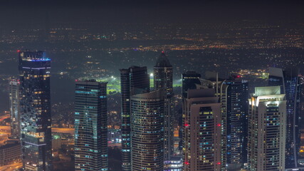 Fototapeta na wymiar JLT skyscrapers near Sheikh Zayed Road aerial night timelapse. Residential buildings