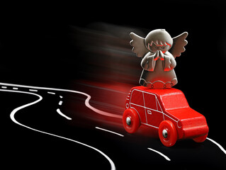 Guardian angel protects red car in road traffic, concept image on black background with copy space