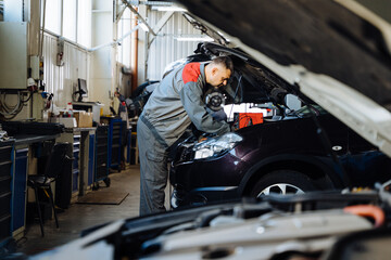 Car service, repair, maintenance concept. Mechanic making diagnostics car in a car repair station.
