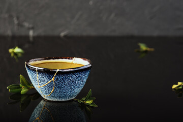 Hot green tea bowl, Japanese tea on a dark background. Selective focus on the cup. Reclaimed...