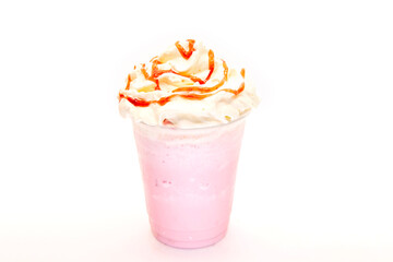 Strawberry milk shake with syrup drizzled on whipped cream in a plastic disposable cup.