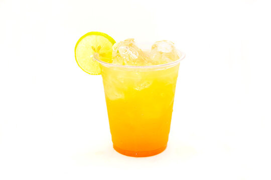 Peach mango drink filled with ice cubes and lemon slice.