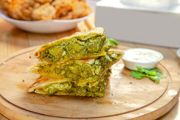 Stuffed naan quesadillas with green chicken tikka and spices baked in wood fired oven.