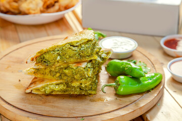 Stuffed naan quesadillas with green chicken tikka and spices baked in wood fired oven.