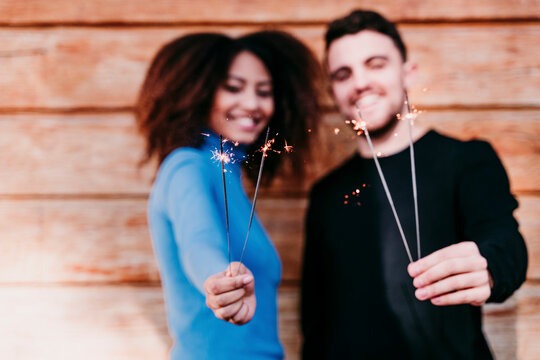 Young man and woman holding sparkler