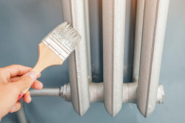 painting of the heating radiator in the apartment with a special silver heat-resistant paint