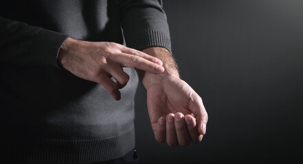 Man checking heart rate pulse on wrist.
