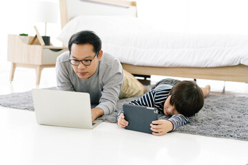 Portrait of Asian father and son obsessed with devices overuse social media , technology addicted...