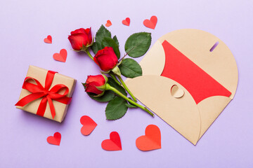 Valentine day composition with envelope, rose flower and red heart on table. Top view, flat lay, copy space Holiday concept
