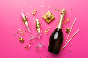 Bottle of champagne with colored glitter, confetti and gift box space for text on colorfull background, top view. Hilarious, christmas and birthday celebration © sosiukin
