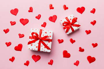 Valentine day composition Background: red gift box with bow and heart. Christmas present. View from above. Holday greeting card