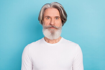 Portrait of attractive content grey-haired middle aged man wearing pullover isolated over vibrant blue color background