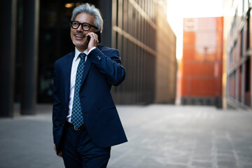 Senior businessman outdoors. Middle-aged businessman talking to the phone