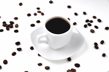 white cup of coffee on a white saucer on a white background isolate, close-up, top view, coffee beans lie on the background