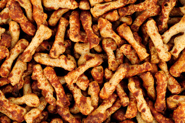 Crunchy knobbly twig shaped wheat savoury party snacks with a yeast flavour coating background