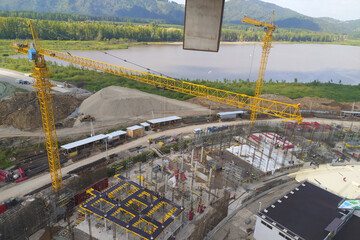 construction of a hotel with the help of tower cranes, in the mountains against the backdrop of beautiful nature