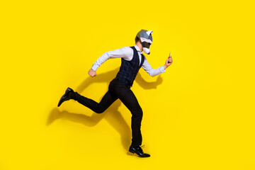 Fototapeta na wymiar Full length photo of freaky guy racoon mask jump run fast use gadget wear trendy stylish vest isolated over yellow color background