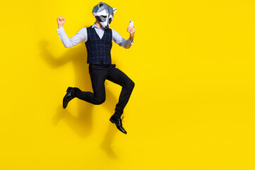 Fototapeta na wymiar Photo of crazy guy racoon mask jump raise fists up win internet smart phone stylish trendy lottery isolated over yellow color background