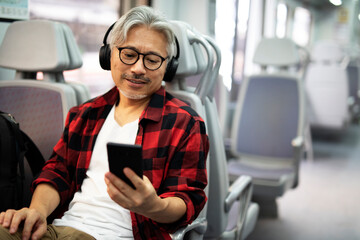 Happy man traveling by train. Man listening the music while enjoying in travel.
