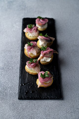 Herring and potato canape, topped with red pickled onion, gourmet norwegian snack