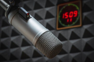professional microphone in sound studio and clock