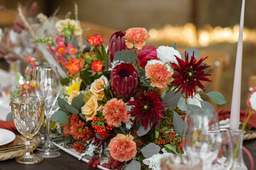 A very nicely decorated wedding table appointments with beautiful decor with plates and serviettes in spring garden. Beautiful flowers on table in wedding day. The elegant dinner table.