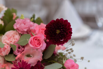 White tablecloths with clear vases and colourful flowers arrangements. Golden colored plates, peavh napkins, table numbers and mirror centerpieces.