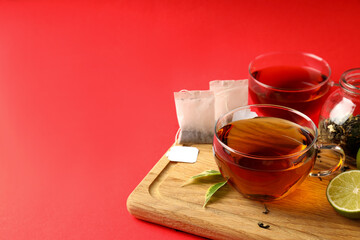 Concept of hot drink with tea on red background