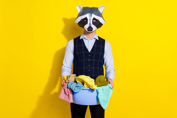 Photo of washer guy hold basin full clothes laundry ad wear raccoon mask vest isolated yellow color background © deagreez