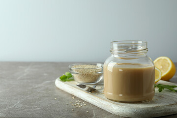 Concept of tasty food with tahini sauce on beige textured table