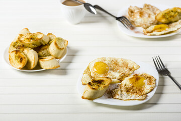 fried eggs, baguette with herb butter and coffee