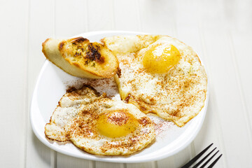 fried eggs, baguette with herb butter and coffee