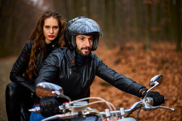 Obraz premium Couple of motorcyclists with a chopper in the woods in the fall.