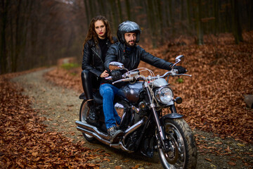 Fototapeta na wymiar Couple of motorcyclists with a chopper in the woods in the fall.
