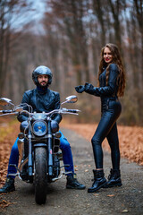 Fototapeta na wymiar Couple of motorcyclists with a chopper in the woods in the fall.